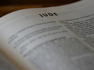 A close-up shot of a Bible opened to the Book of Jude, highlighting the text vividly.